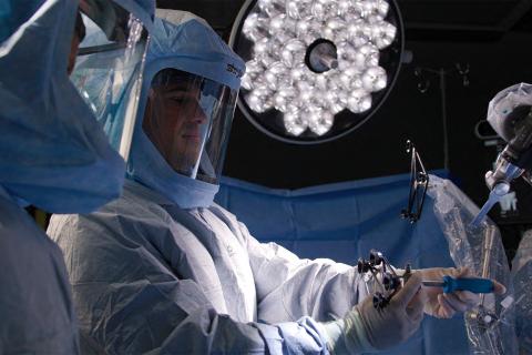 Adam Stillo holding medical equipment in operating room