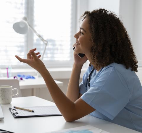 A woman in healthcare talking on the phone