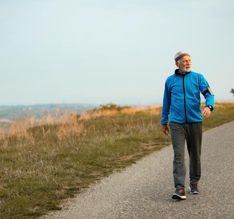 Senior man walking on path outside